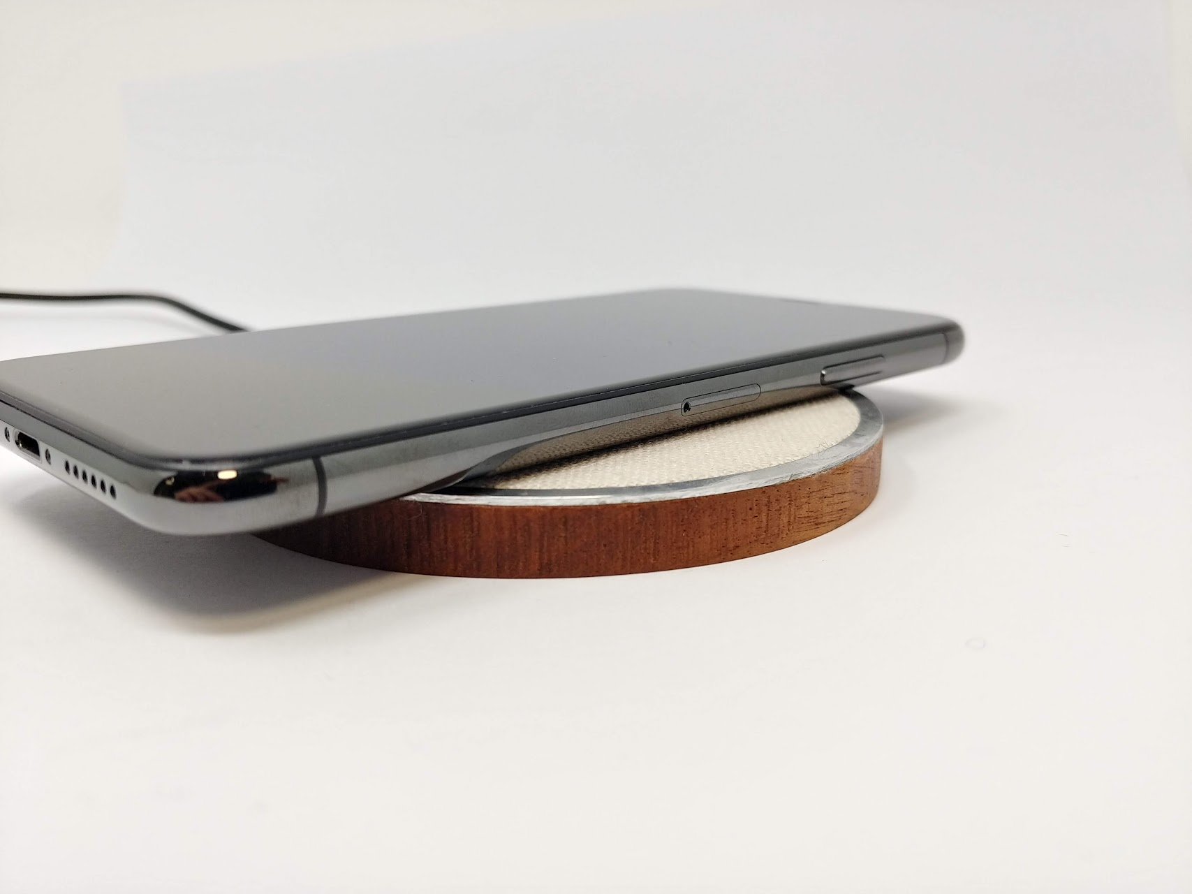 EFD.1 — a wireless charger machined from mahogany, aluminium and linen, with a phone charging on top